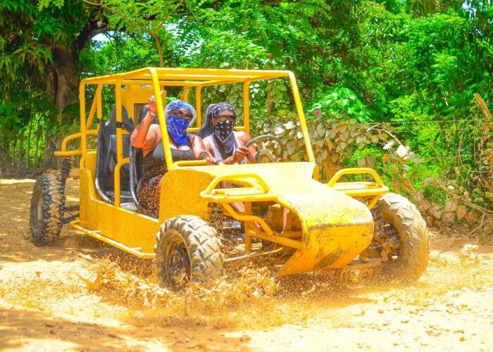 Excursia Punta Cana adventure with guests in a yellow buggy on a dirt road