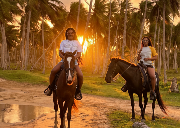 Two women horseback riding at sunset in Punta Cana's lush landscape