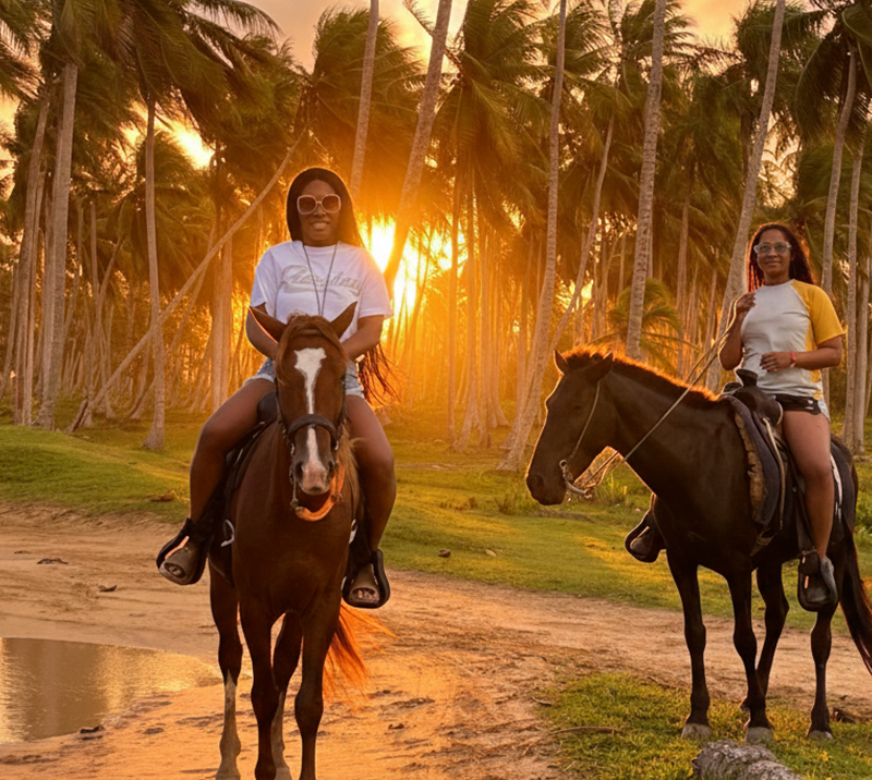 Two women horseback riding at sunset in Punta Cana's lush landscape